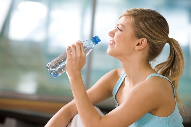 Beautiful woman holding bottles drinking water | Reasons to Love Tyent Water Ionizers | press