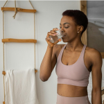 Woman in activewear drinking water.